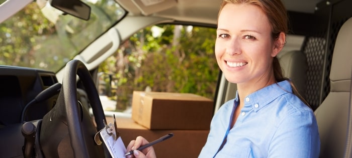 Woman Facing Camera Smiling Sitting In Van Delivering Min